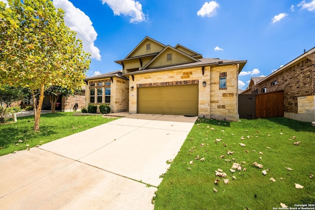 view of front of property featuring fence, stone siding, a front lawn, an attached garage, and driveway