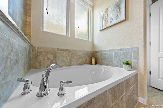 full bathroom featuring a garden tub and a textured wall