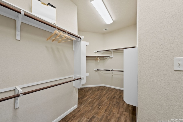 walk in closet with wood finished floors