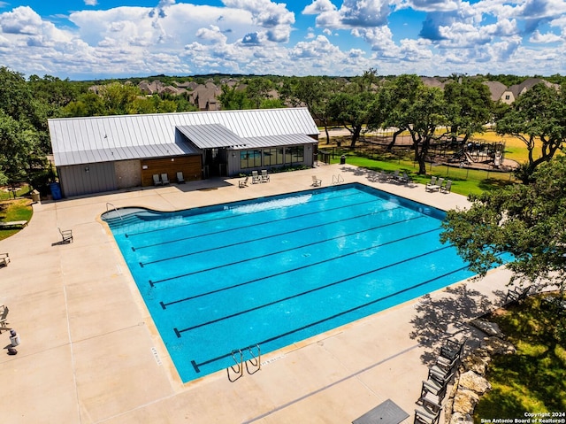 community pool with a patio and fence