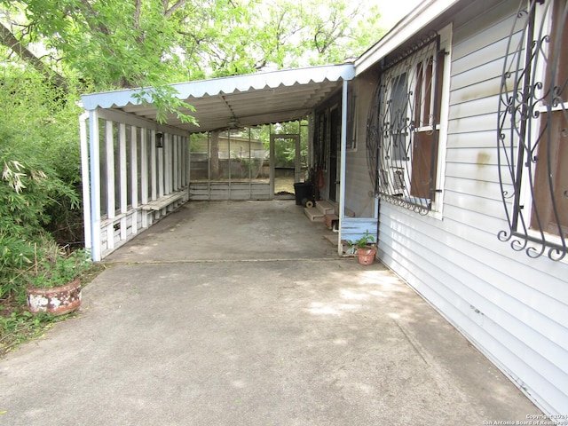 view of patio with concrete driveway and an attached carport