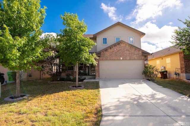 traditional-style house with a front yard, concrete driveway, brick siding, and an attached garage