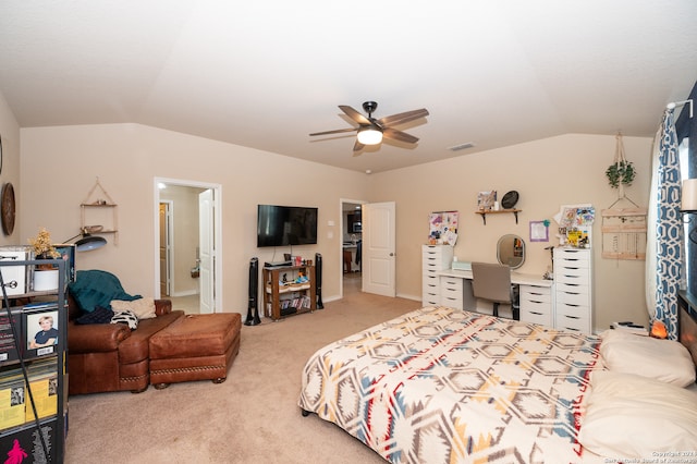 bedroom with vaulted ceiling, light colored carpet, ensuite bathroom, and ceiling fan