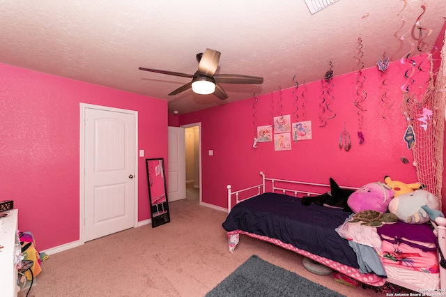 carpeted bedroom with ceiling fan and a textured ceiling