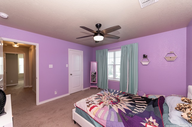 carpeted bedroom featuring a textured ceiling and ceiling fan