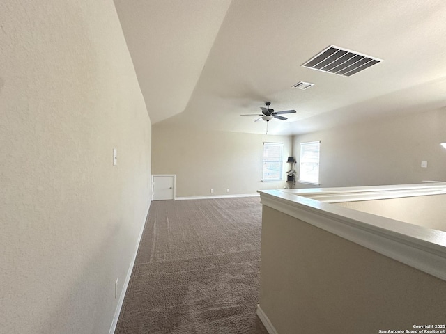 hallway with carpet flooring, visible vents, and baseboards