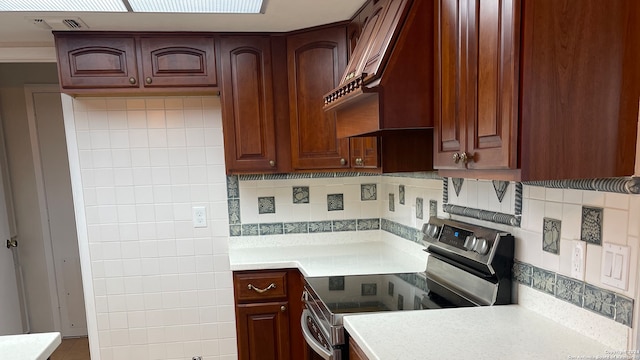 kitchen featuring custom range hood, backsplash, and electric range