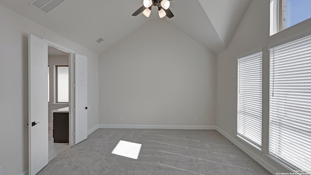 unfurnished bedroom featuring ceiling fan, lofted ceiling, and light colored carpet