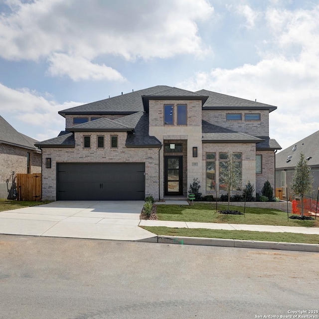 prairie-style house with a garage and a front lawn