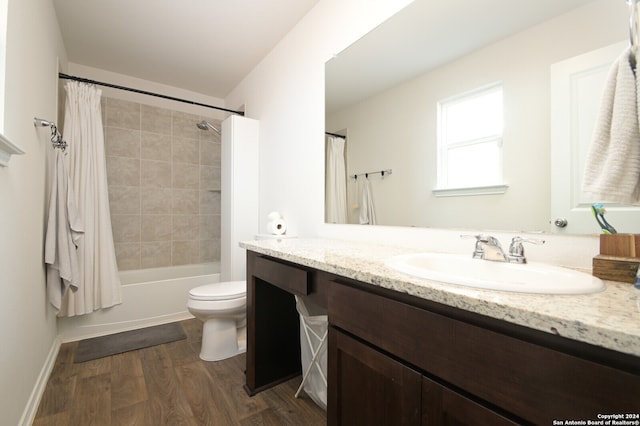 full bathroom with wood-type flooring, toilet, shower / tub combo with curtain, and vanity