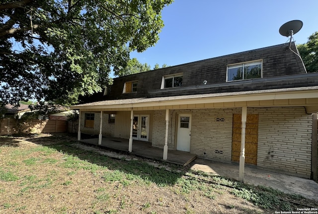 rear view of property featuring a lawn and a patio