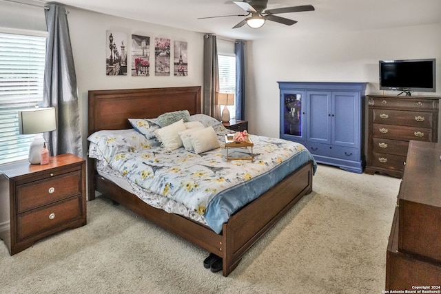 bedroom featuring light carpet and ceiling fan