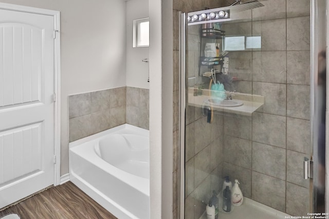 bathroom featuring hardwood / wood-style flooring and plus walk in shower