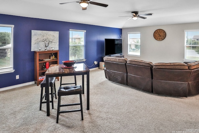 carpeted living room with a wealth of natural light, ceiling fan, and lofted ceiling