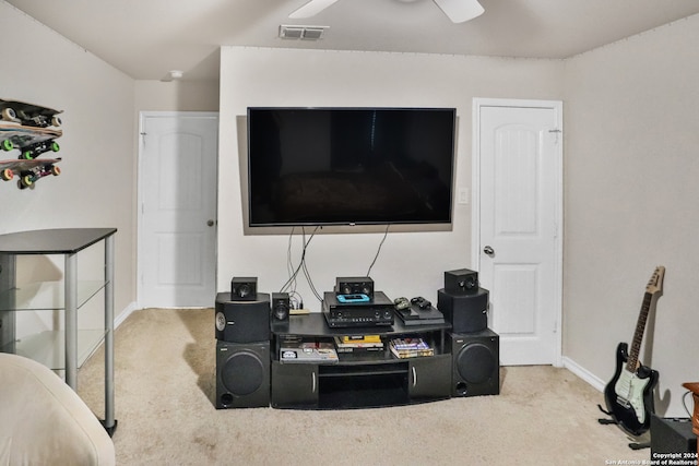 carpeted home theater room with ceiling fan