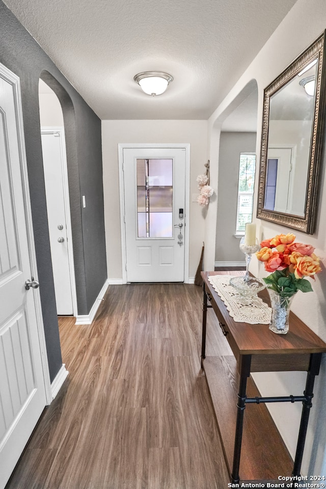 doorway with wood-type flooring and a textured ceiling