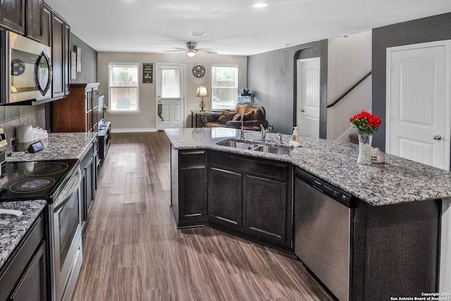 kitchen featuring stainless steel appliances, dark hardwood / wood-style flooring, sink, an island with sink, and ceiling fan