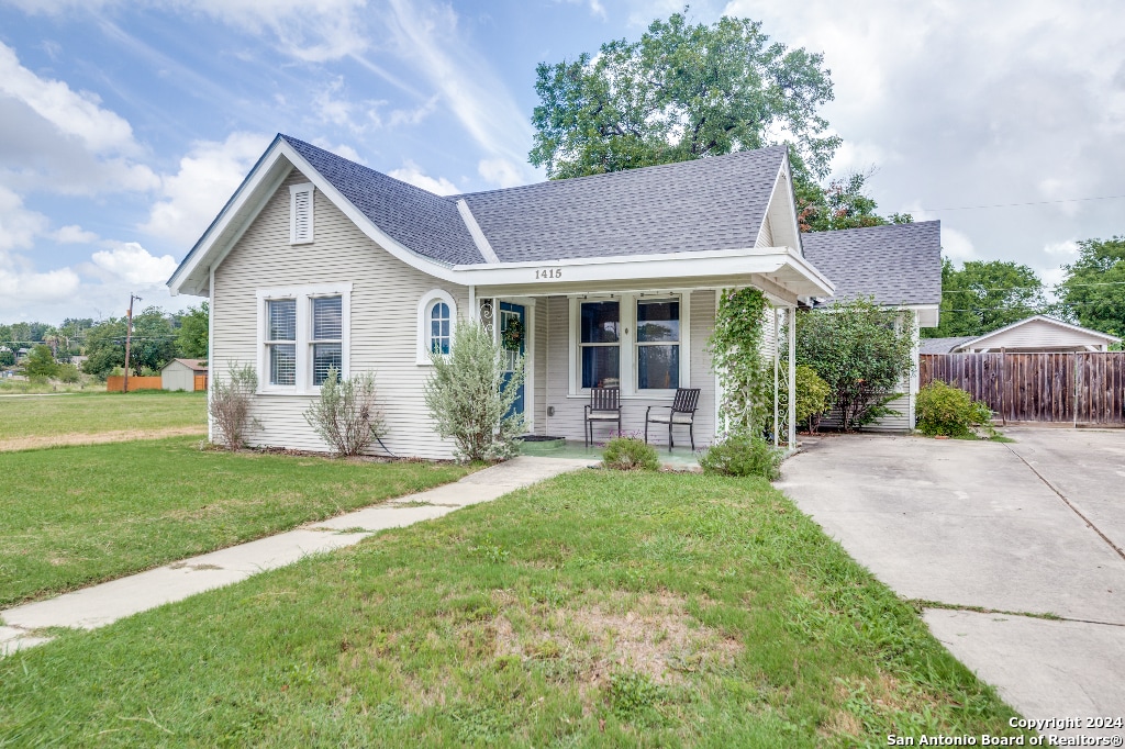 view of front of house with a porch and a front lawn