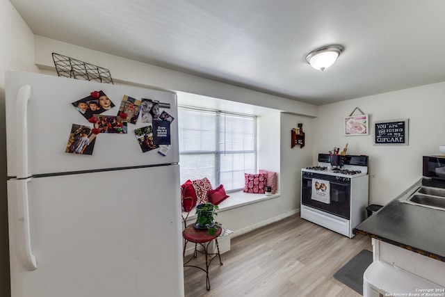 kitchen with white appliances and light hardwood / wood-style flooring