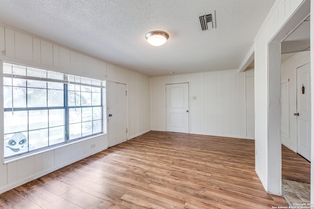 interior space featuring a textured ceiling and light wood-type flooring