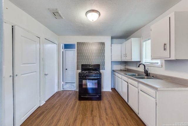 kitchen featuring white cabinets, black gas range oven, dark hardwood / wood-style flooring, sink, and a textured ceiling