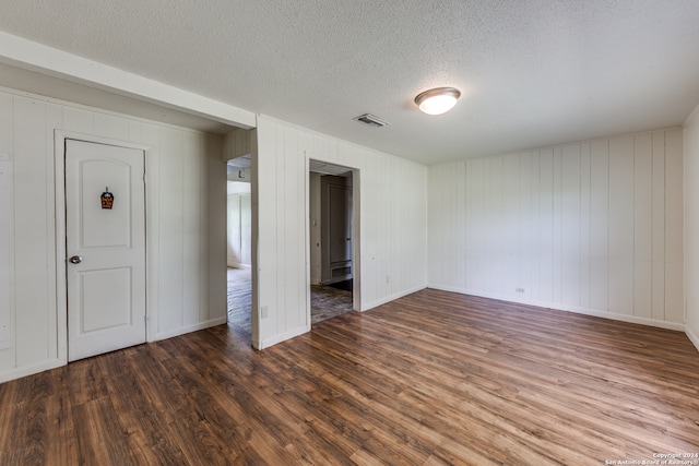 unfurnished bedroom with a textured ceiling and dark wood-type flooring