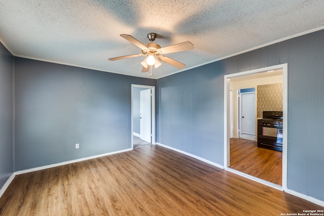 spare room with a textured ceiling, ceiling fan, ornamental molding, and hardwood / wood-style floors