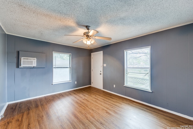 spare room featuring ceiling fan, a wealth of natural light, hardwood / wood-style flooring, and a textured ceiling