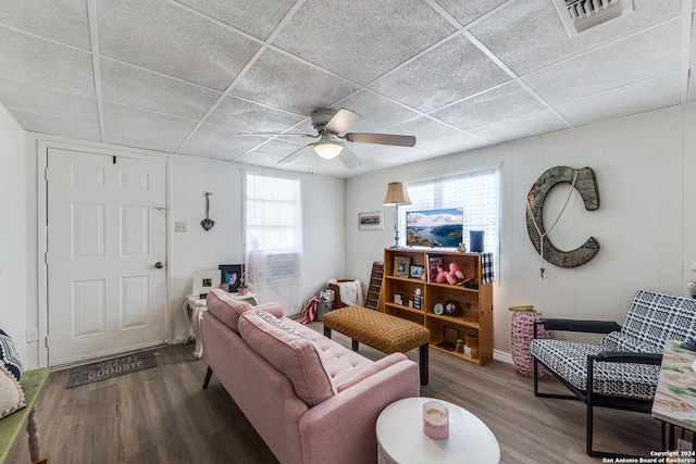 living room with ceiling fan, hardwood / wood-style floors, and a drop ceiling