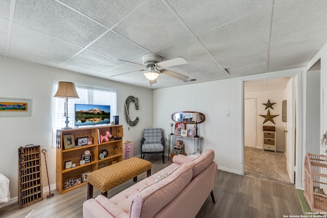 living room featuring hardwood / wood-style floors, ceiling fan, and a drop ceiling