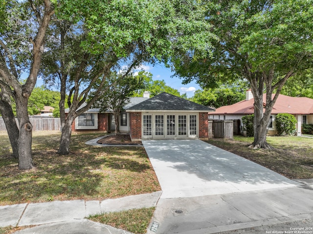 ranch-style house with french doors and a front lawn