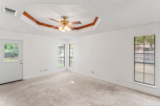 spare room with a raised ceiling, ceiling fan, and a healthy amount of sunlight