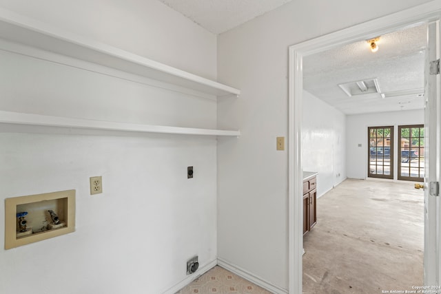 laundry room featuring hookup for an electric dryer, a textured ceiling, and hookup for a washing machine