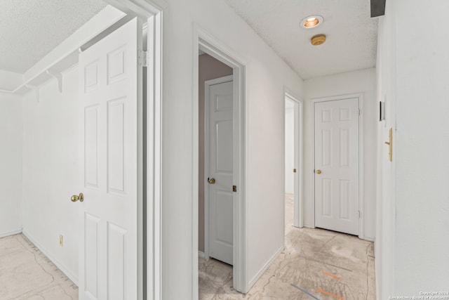 hallway featuring a textured ceiling