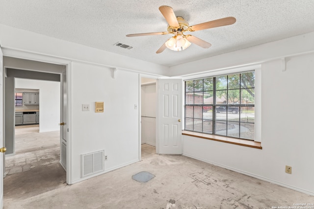 unfurnished bedroom with ceiling fan and a textured ceiling