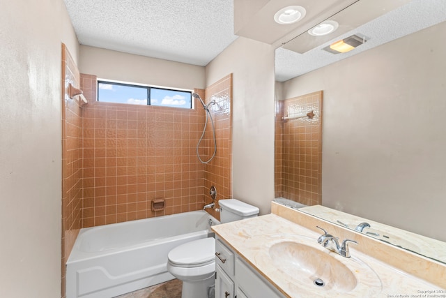 full bathroom with toilet, vanity, a textured ceiling, and tiled shower / bath