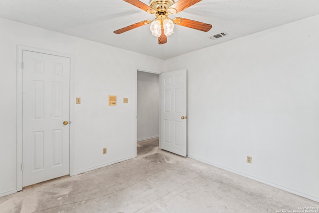 unfurnished room with ceiling fan and a textured ceiling