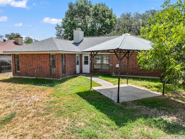 back of property featuring a lawn and a patio