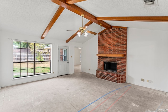 unfurnished living room featuring a textured ceiling, lofted ceiling with beams, a brick fireplace, and ceiling fan