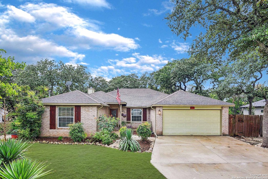 single story home featuring a garage and a front lawn