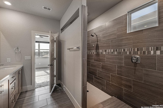 full bathroom featuring visible vents, walk in shower, vanity, and baseboards