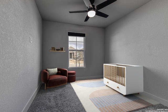 bedroom with carpet flooring, a textured wall, baseboards, and ceiling fan