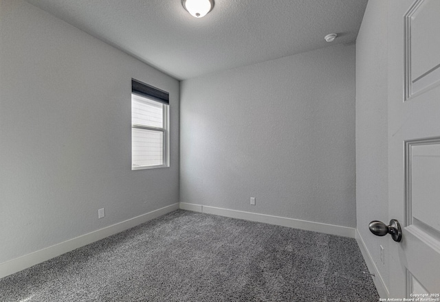 carpeted spare room with baseboards and a textured ceiling