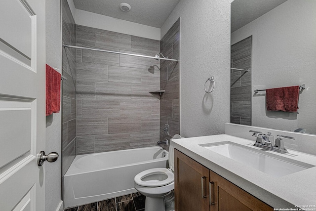 full bathroom featuring a textured wall, toilet, washtub / shower combination, wood tiled floor, and vanity