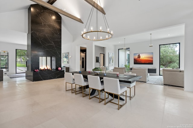 dining space with an inviting chandelier, beamed ceiling, a fireplace, tile walls, and high vaulted ceiling