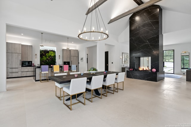 dining space with beamed ceiling, a fireplace, a notable chandelier, tile walls, and high vaulted ceiling