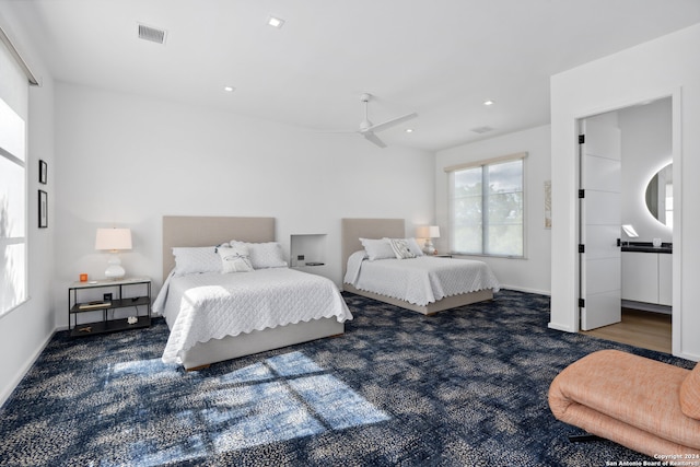 bedroom featuring dark carpet, ceiling fan, and ensuite bathroom