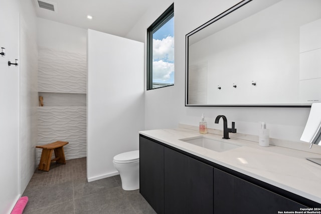 bathroom featuring vanity, toilet, and tile patterned floors