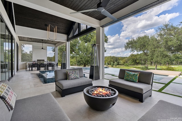 view of patio / terrace with a water view, ceiling fan, and an outdoor living space with a fire pit