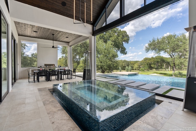 view of swimming pool with an in ground hot tub, ceiling fan, and a patio